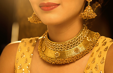 Woman wearing traditional gold necklace and earnings Woman wearing traditional gold necklace and earnings