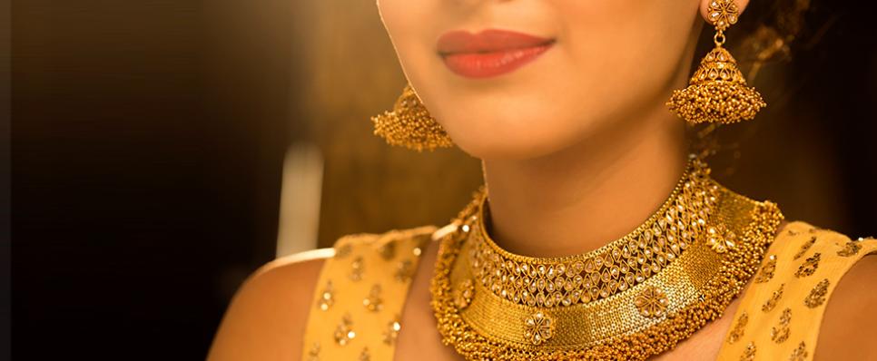 Woman wearing traditional gold necklace and earnings Woman wearing traditional gold necklace and earnings